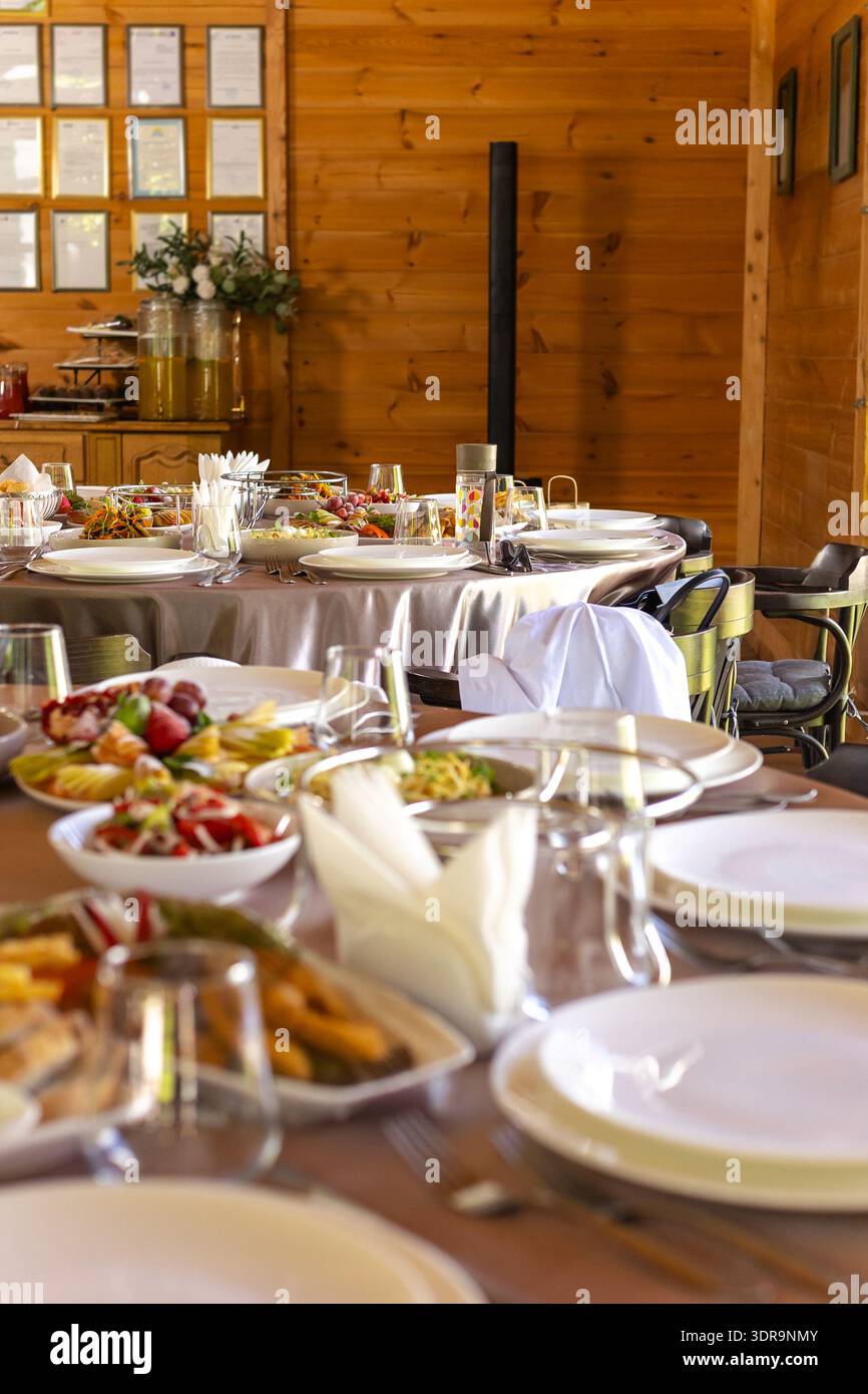 Table de banquet avec salades, fruits et hors-d'œuvre dans un lieu en bois. Banque D'Images