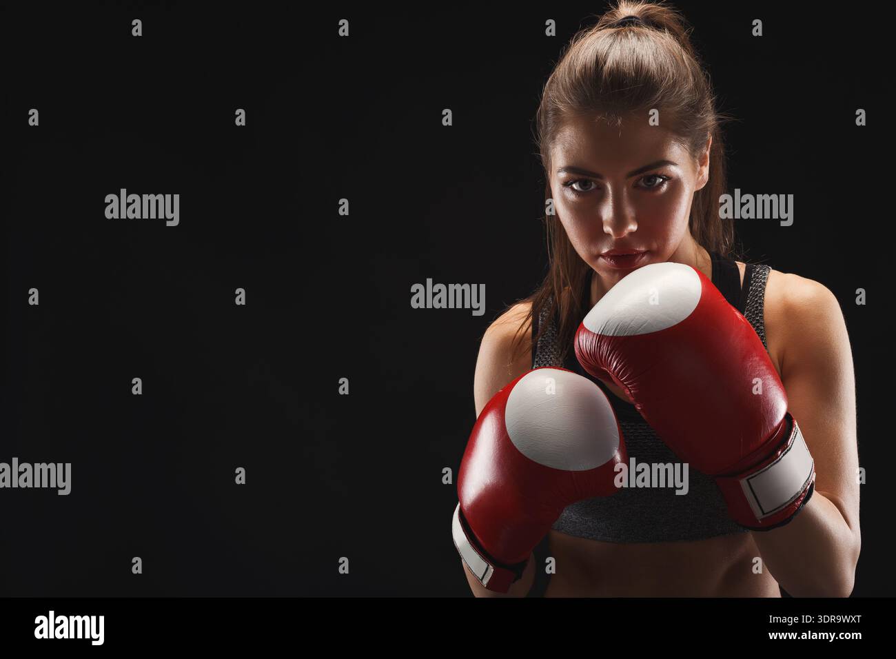 Séance d'entraînement de boxe avec une femme en gants rouges se préparant à Spar Banque D'Images