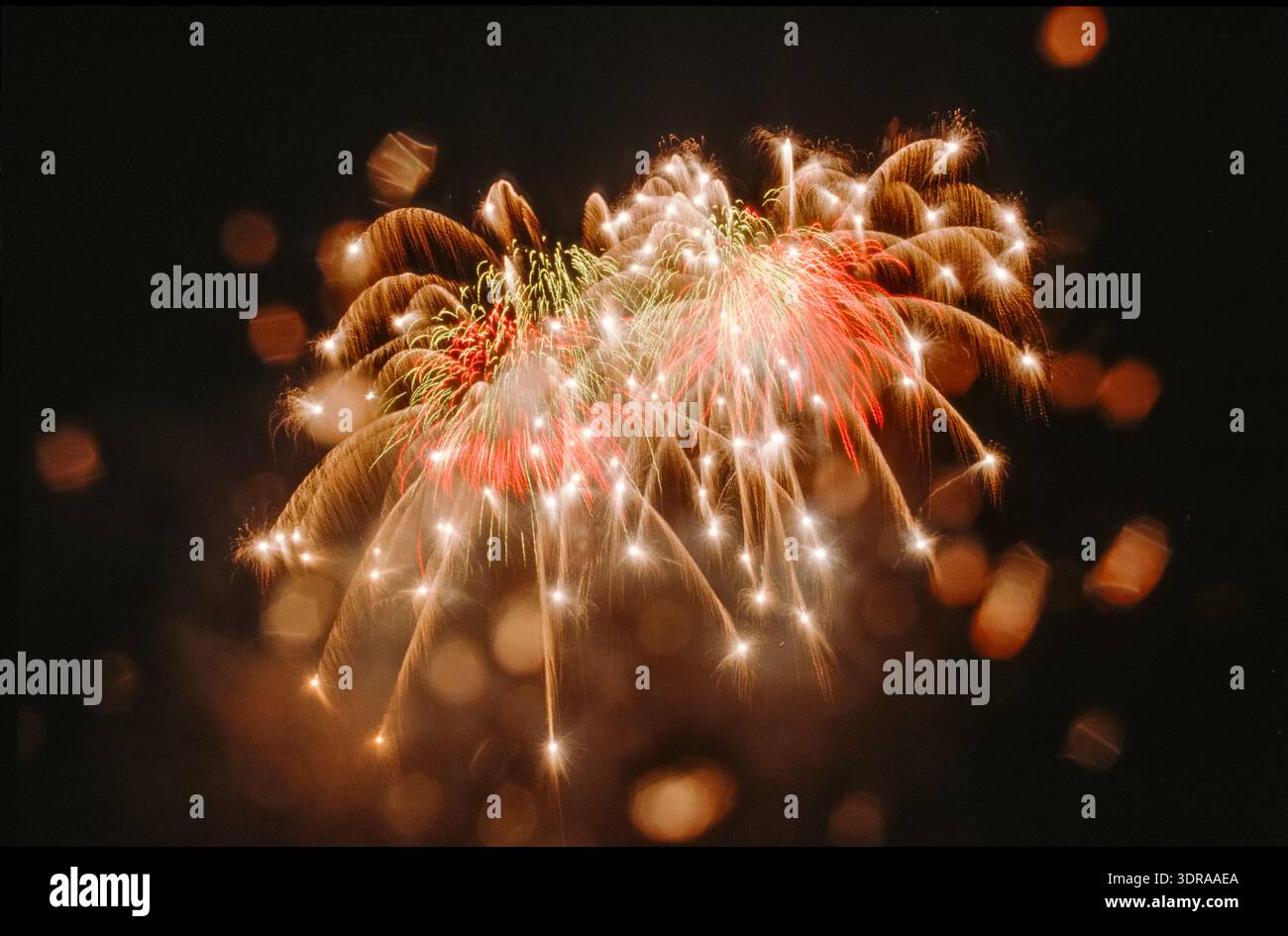 Feux d'artifice à haute altitude dans le ciel nocturne sous la pluie avec des taches d'objectif ou des taches d'ouverture Banque D'Images
