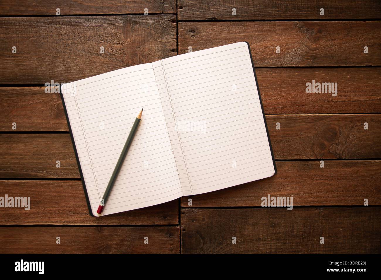 Ouvrez le cahier et le crayon sur une planche de bois rustique Banque D'Images