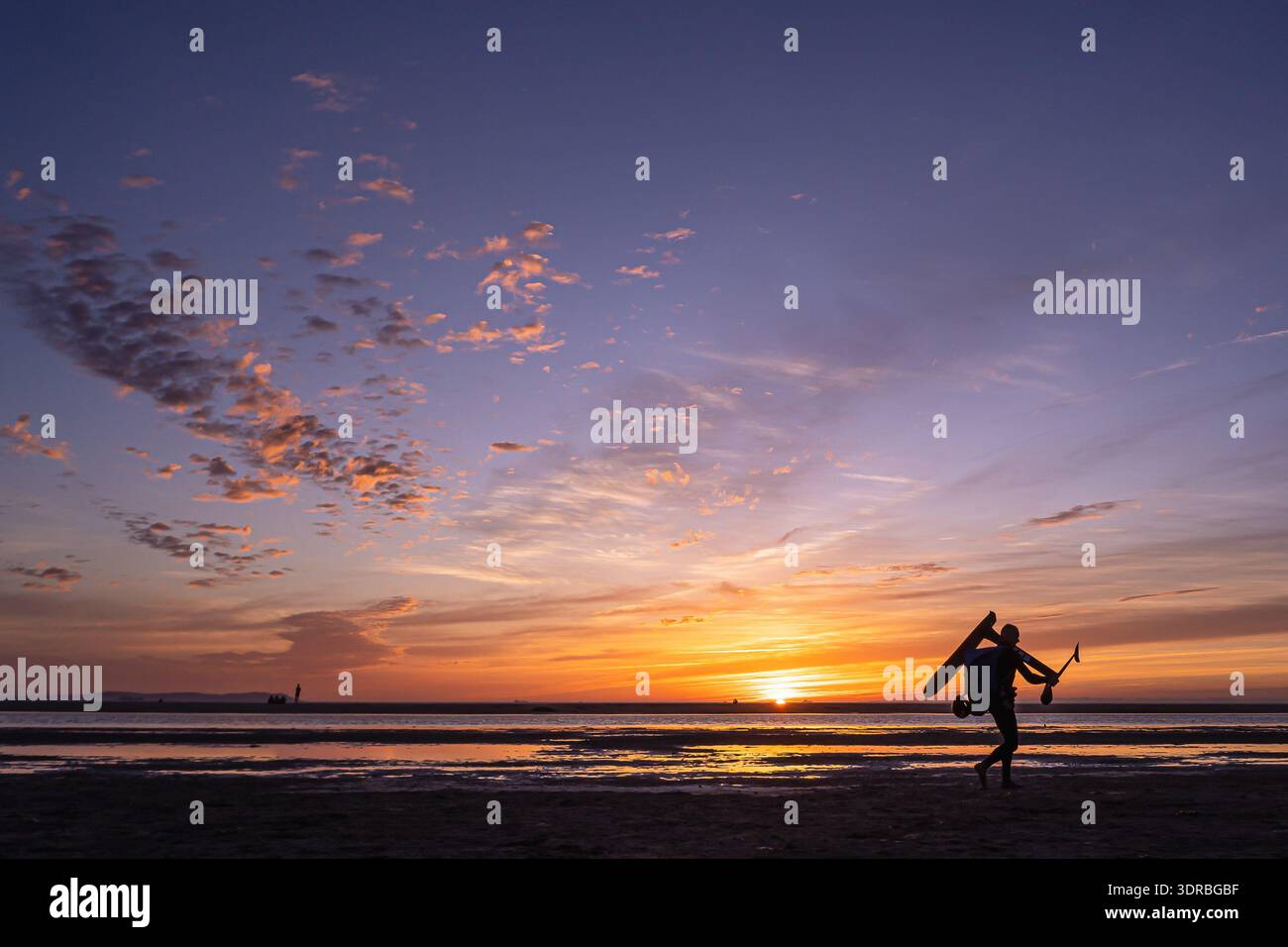 Silhouette de voilure surfeur portant le matériel au coucher du soleil, Tarifa Cadiz, Espagne Banque D'Images