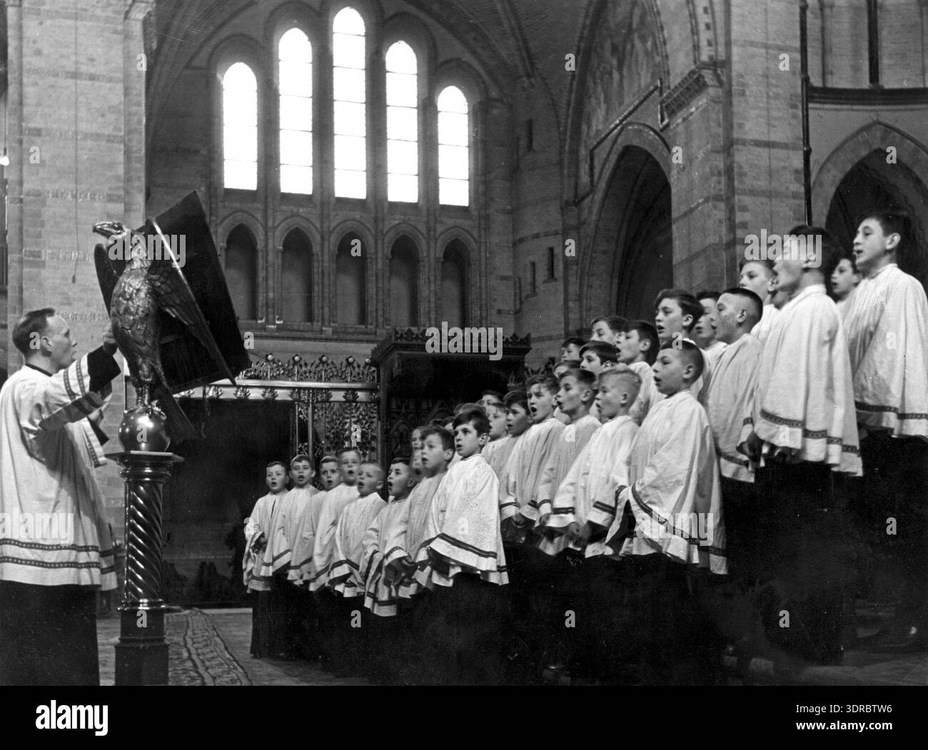 La photographie montre le chœur de garçons de la cathédrale de la Basilique catholique romaine équipée Bavo à Haarlem en 1941. Le chef d'orchestre Dr de Kat se tient à côté du pupitre. L’image documente les traditions chorales néerlandaises, la musique religieuse, l’organisation de chœurs de garçons, la performance vocale, la musique liturgique, la culture musicale de la cathédrale, et l'éducation historique en musique. Banque D'Images
