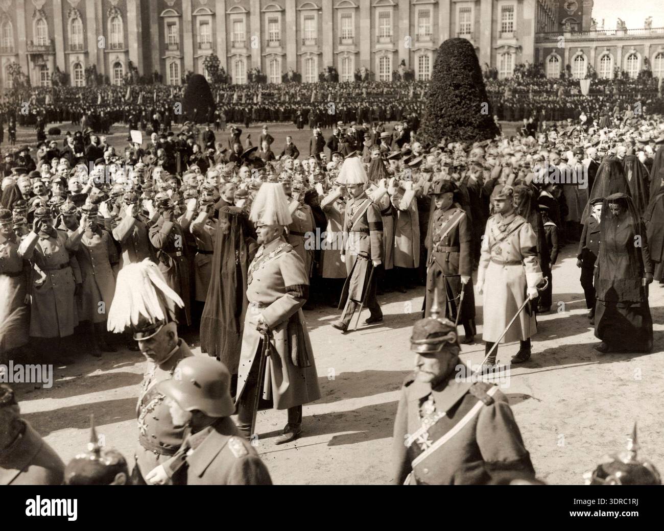 Cette photographie de 1921 par A. & E. Frankl montre le cortège funèbre de l'ex-impératrice Augusta Victoria en Allemagne, avec les participants de devant, notamment le prince Eitel Friedrich et l'ex-princesse héritière Cecilie, suivis par la princesse August, Adalbert et Oscar. L'image documente le protocole de la famille impériale allemande, la procession cérémonielle et l'observation publique des événements funéraires à Potsdam au début du XXe siècle. Banque D'Images