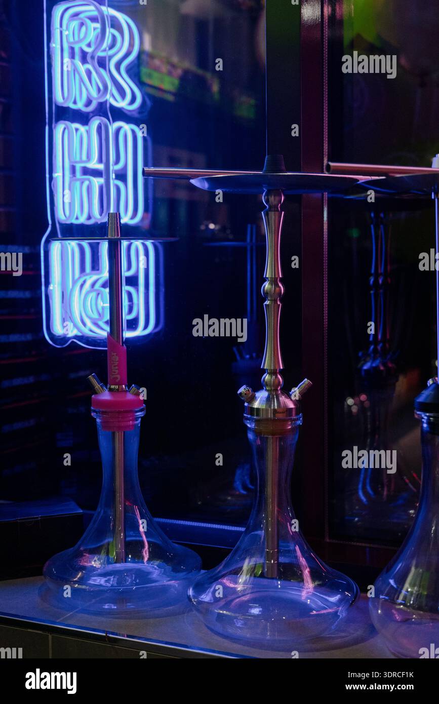 Hookahs en verre sur un comptoir de bar dans une discothèque avec éclairage au néon.hookahs modernes en verre et en métal dans un salon de hookah avec néon bleu Banque D'Images