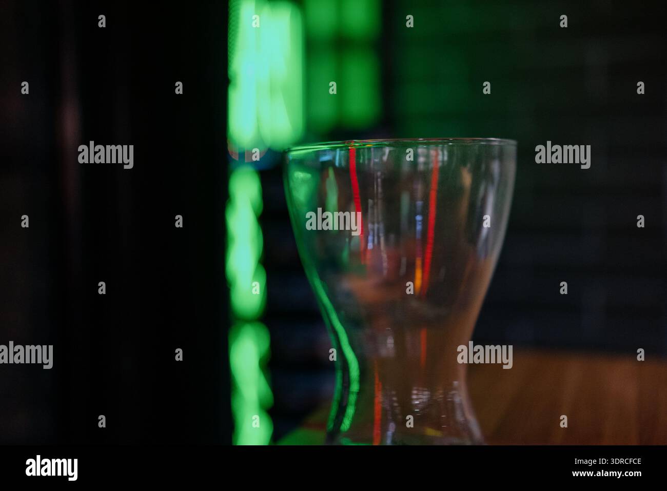 Deux hookahs en verre modernes sur un support en bois dans un intérieur sombre avec éclairage au néon.hookahs professionnels assemblés contre un mur de briques et néon vert dedans Banque D'Images