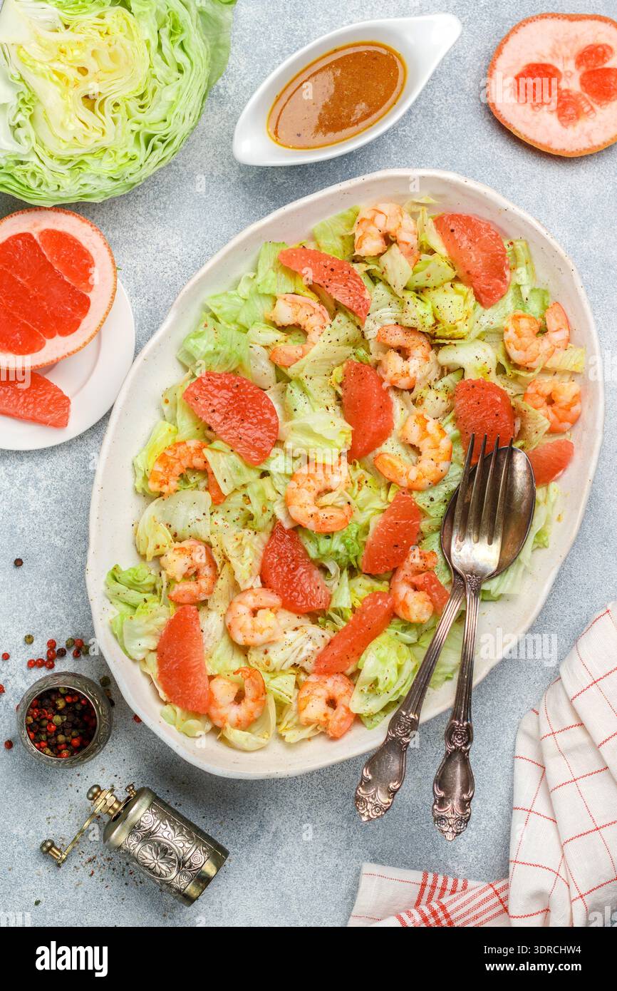Salade de crevettes (crevettes) avec tranches de pamplemousse, laitue fraîche et huile d'olive et vinaigrette à la moutarde avec épices et assaisonnements dans un W. Banque D'Images