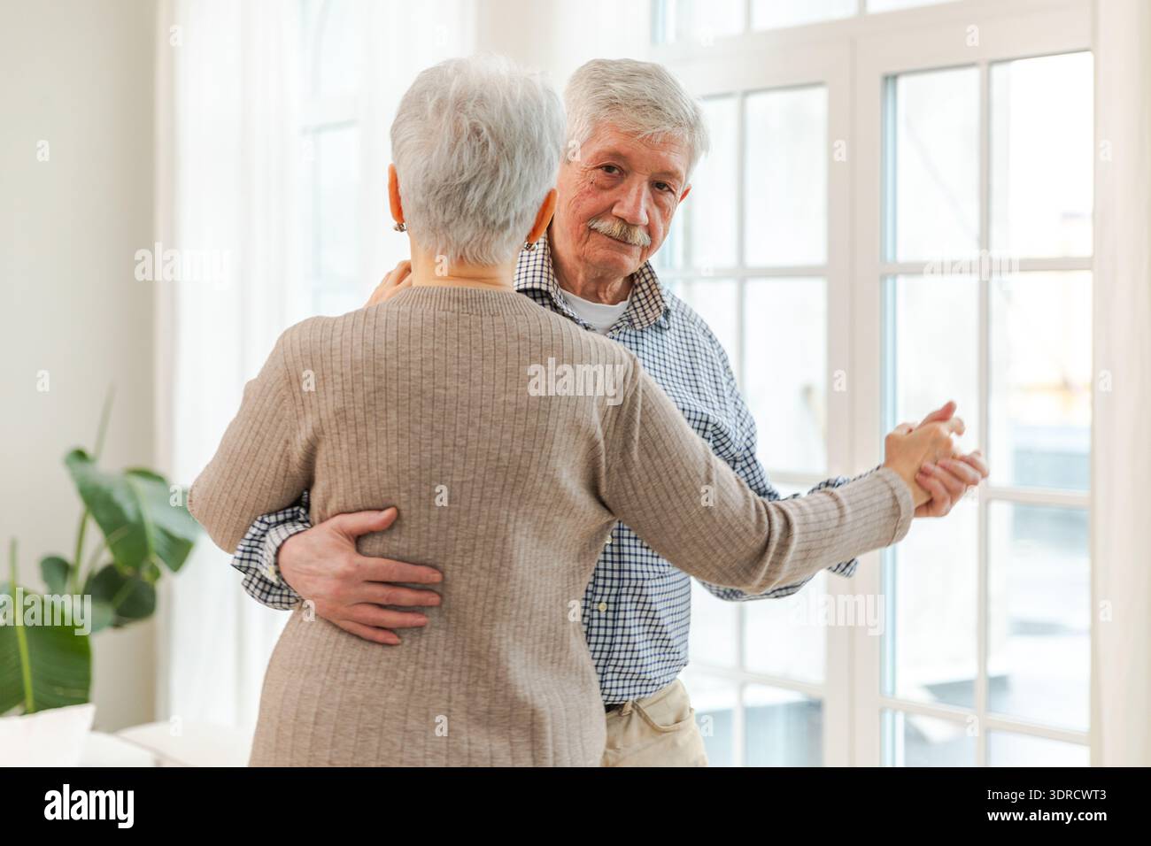 Continuez à bouger. Couple senior romantique dansant sur la musique ensemble à la maison. Heureuse famille souriante homme retraité femme mari wif Banque D'Images