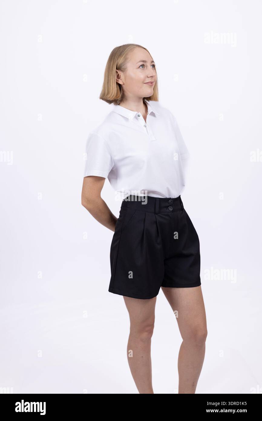 Jeune femme en chemise blanche et jupe noire posant en studio Banque D'Images