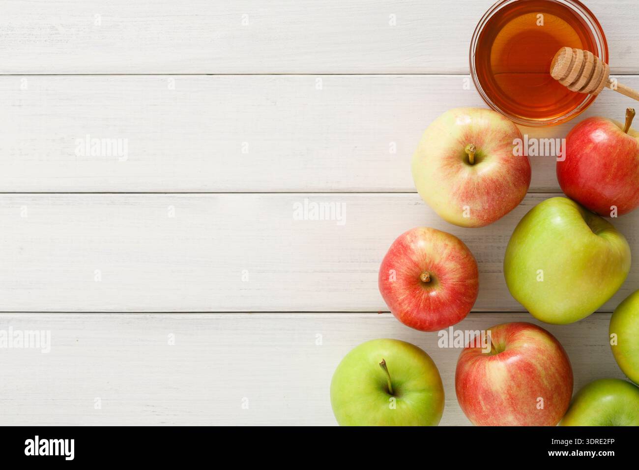 Différents types de pommes disposées avec du miel sur une table en bois Banque D'Images