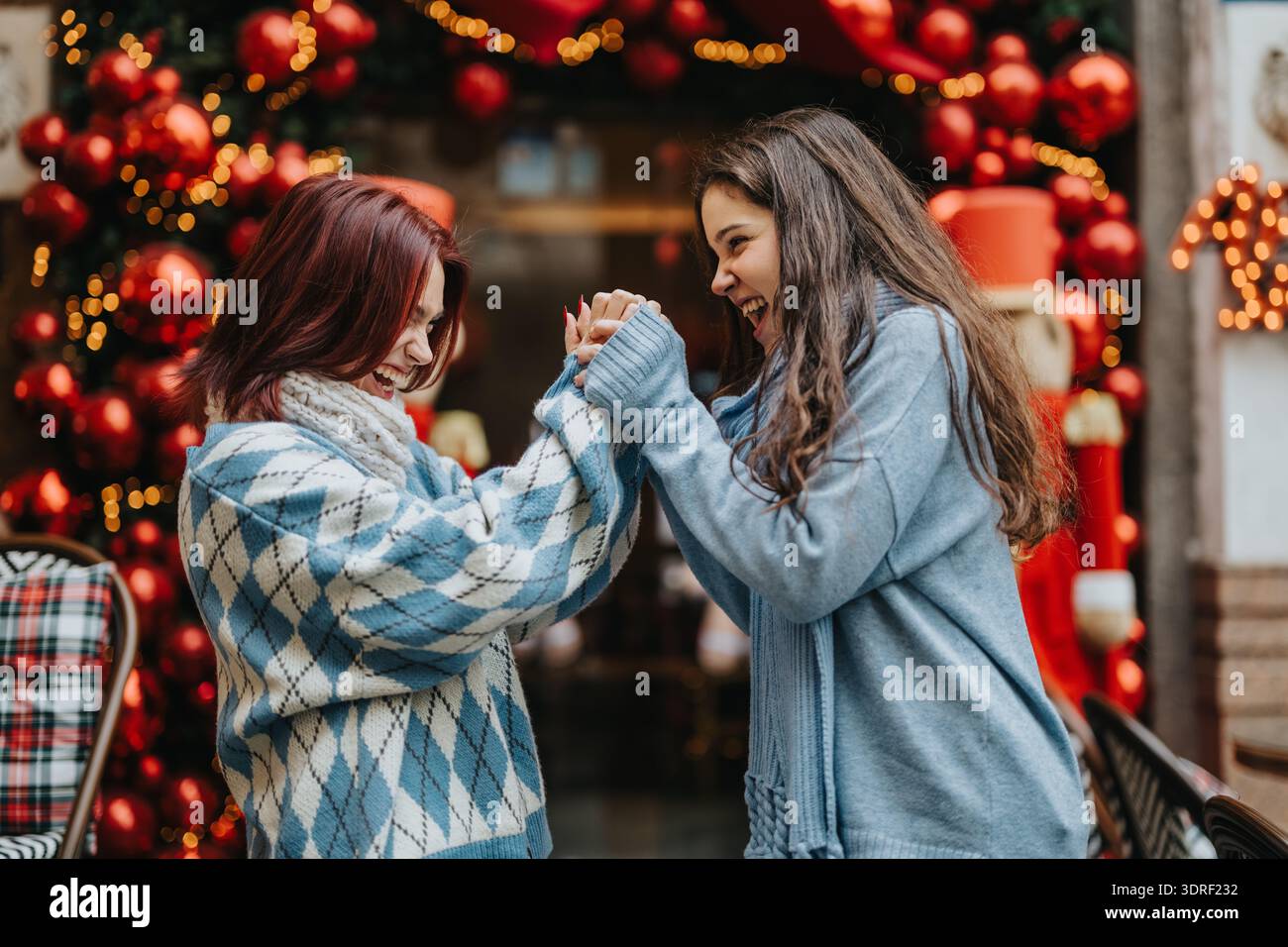 Deux amis adolescents rient et s'enchaînent dans un cadre festif de Noël Banque D'Images