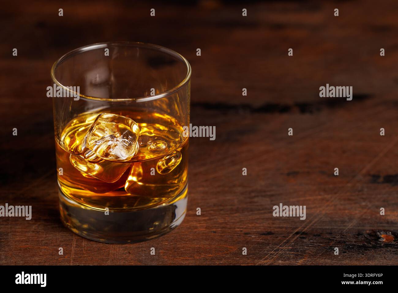 Un verre de whisky classique rempli de whisky ambré doré Banque D'Images