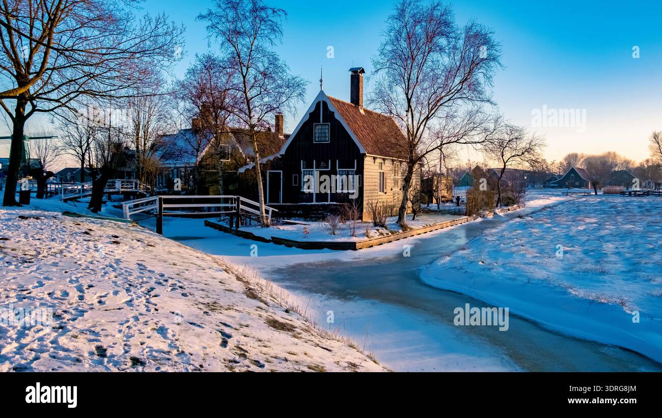 Paysage hivernal captivant avec un chalet pittoresque dans un cadre de village enneigé à l'aube Banque D'Images