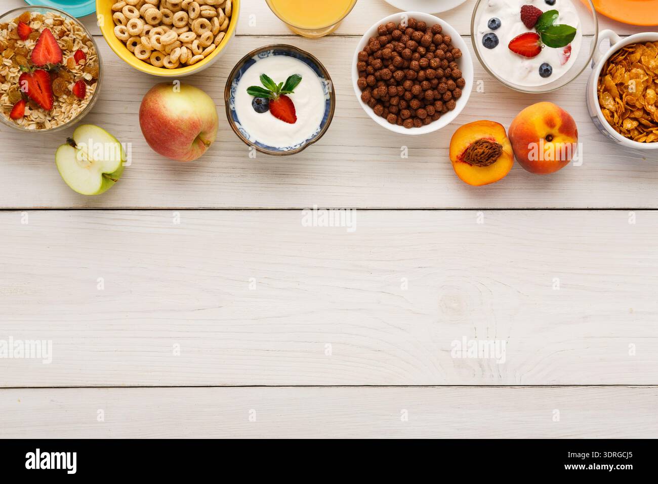 Le petit-déjeuner comprend des fruits, des céréales et des yaourts sur la table en bois blanc Banque D'Images
