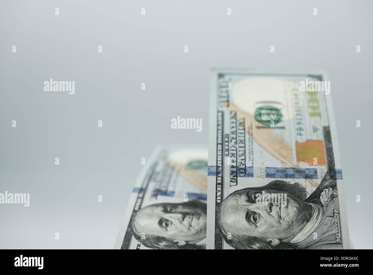 Deux billets de cent dollars avec une faible profondeur de champ sur un fond gris et vide. Minimalisme. Copier l'espace. Banque D'Images