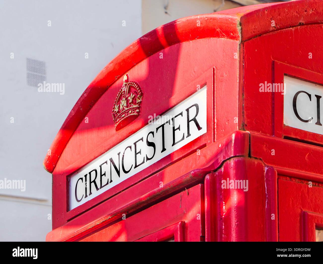 Gros plan sur le détail supérieur d'une cabine téléphonique britannique rouge traditionnelle à Cirencester avec l'emblème de la couronne royale et le texte Cirencester Banque D'Images