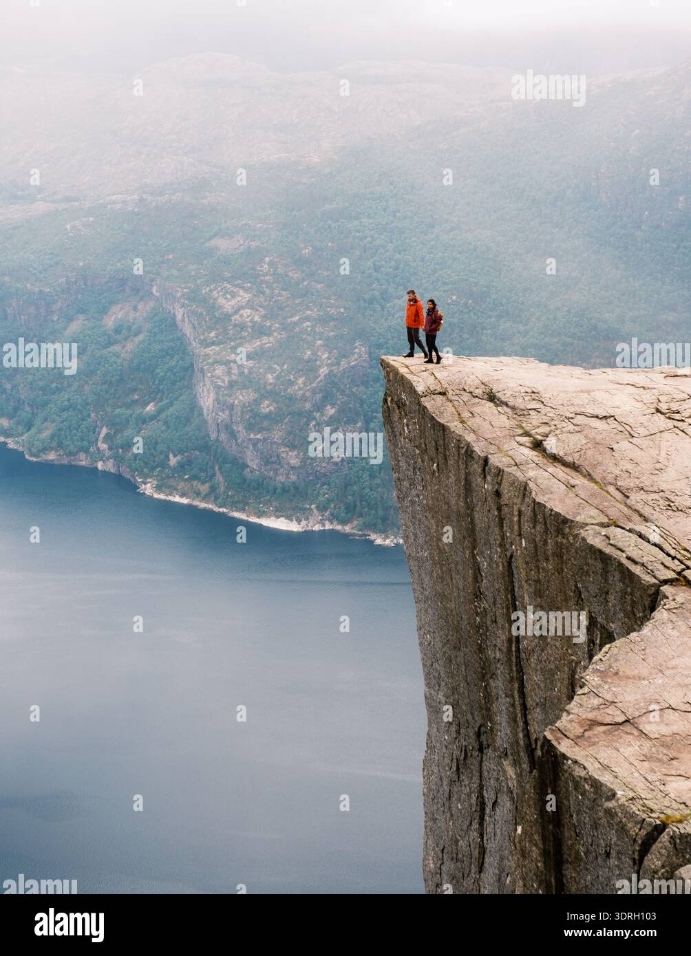 Vue imprenable depuis Pulpit Rock en Norvège avec des randonneurs aventureux explorant le bord des falaises Banque D'Images