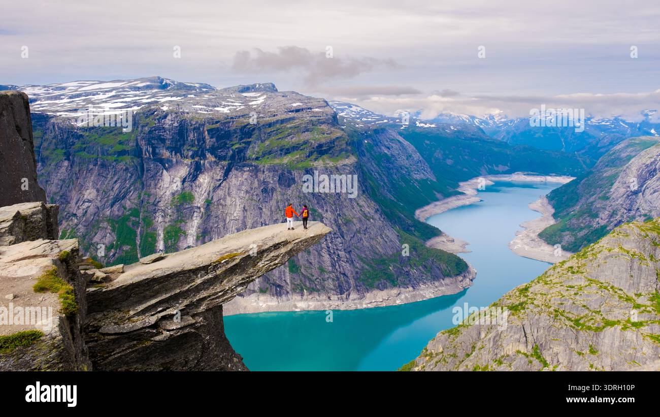 Vue imprenable depuis le bord d'une falaise en Norvège avec des randonneurs surplombant le fjord Banque D'Images
