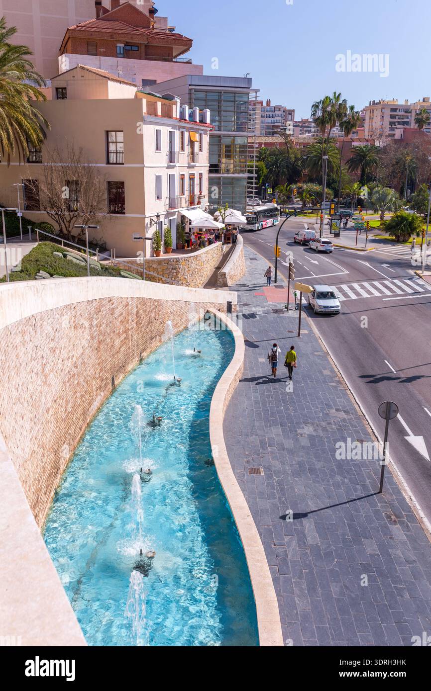 Malaga, Espagne – 11 février 2020 : une vue surélevée de la fontaine moderne Cascada de la Coracha présente des jets d'eau en cascade le long d'un trottoir de pierre Banque D'Images