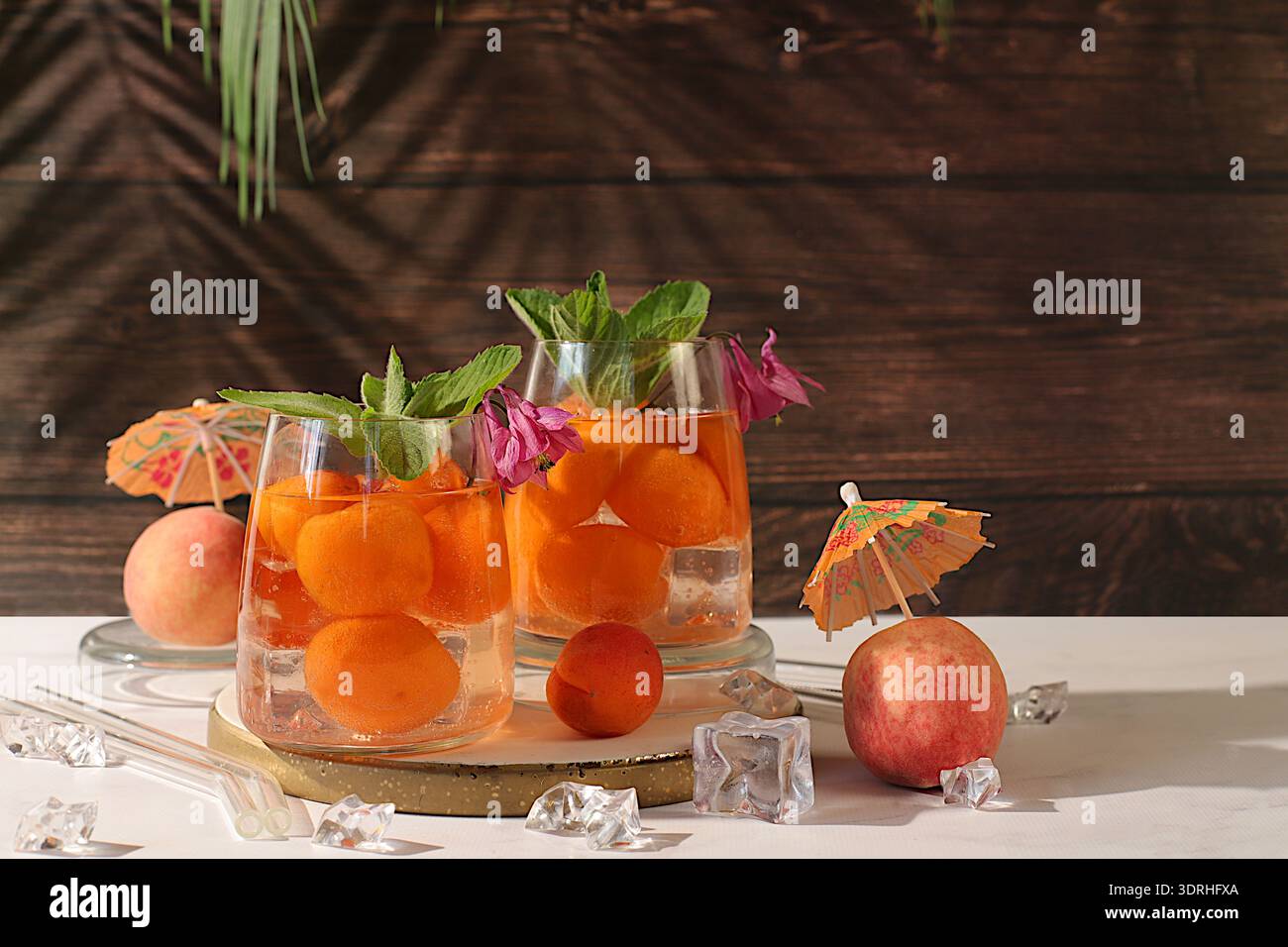 Thé de pêche glacé ou cocktail à la menthe et aux abricots, recette rafraîchissante de boisson estivale. Deux verres avec limonade de fruits de pêche sur un RU Banque D'Images