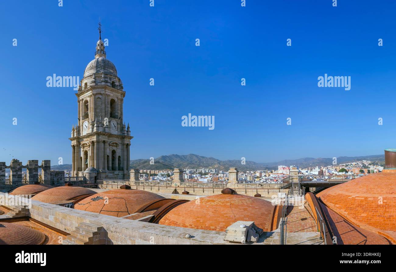 Large panorama sur le toit de la cathédrale de Malaga avec dômes en terre cuite et clocher. Espagne. Soleil brillant sur la ville méditerranéenne. Paysage architectural et hi Banque D'Images