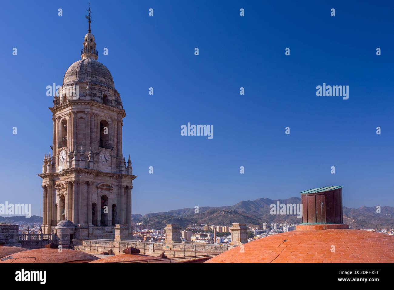 Large panorama sur le toit de la cathédrale de Malaga avec dômes en terre cuite et clocher. Espagne. Soleil brillant sur la ville méditerranéenne. Paysage architectural et hi Banque D'Images