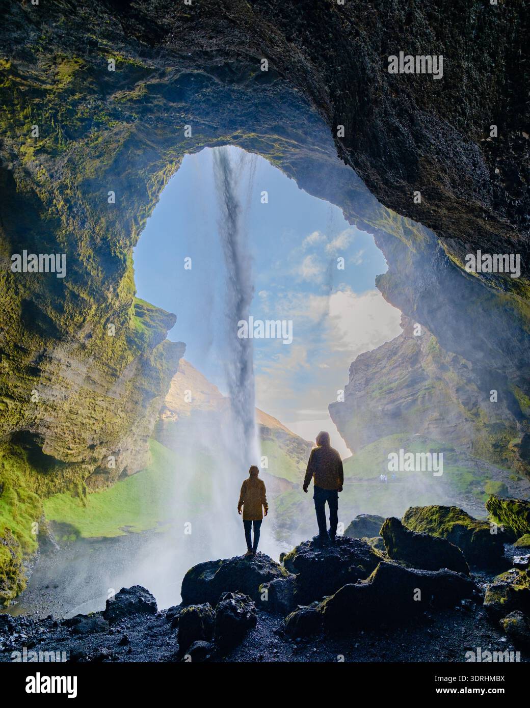Cascade majestueuse en cascade à travers une grotte à flanc de falaise en Islande au lever du soleil Banque D'Images