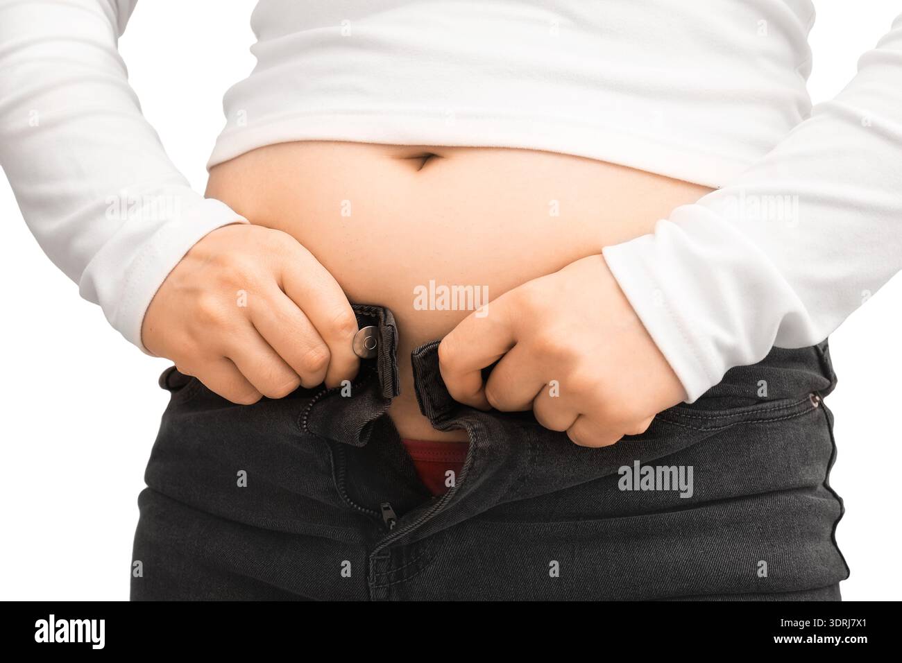 Gros plan d'une personne luttant pour boutonner un Jean noir serré sur son ventre, isolé sur un fond blanc. Concept de prise de poids, obésité, et mourir Banque D'Images