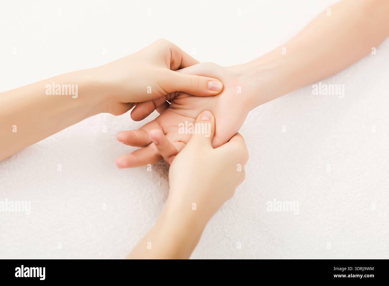 Mains appliquant une pression sur une autre main pendant une séance de massage axée sur les techniques de relaxation Banque D'Images