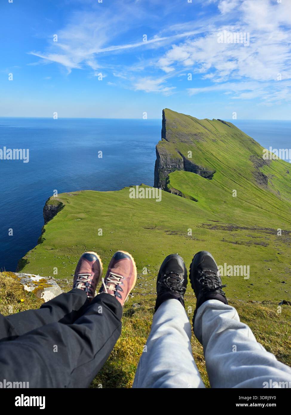 Vue imprenable de Mylingur randonnée dans les îles Féroé avec les randonneurs se reposant sur le bord Banque D'Images