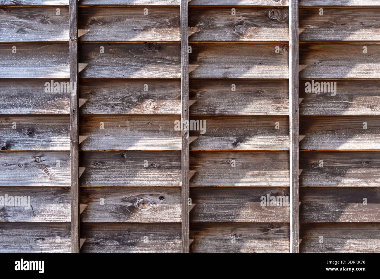 Vieille clôture en bois avec des ombres et des détails de texture vieillis Banque D'Images