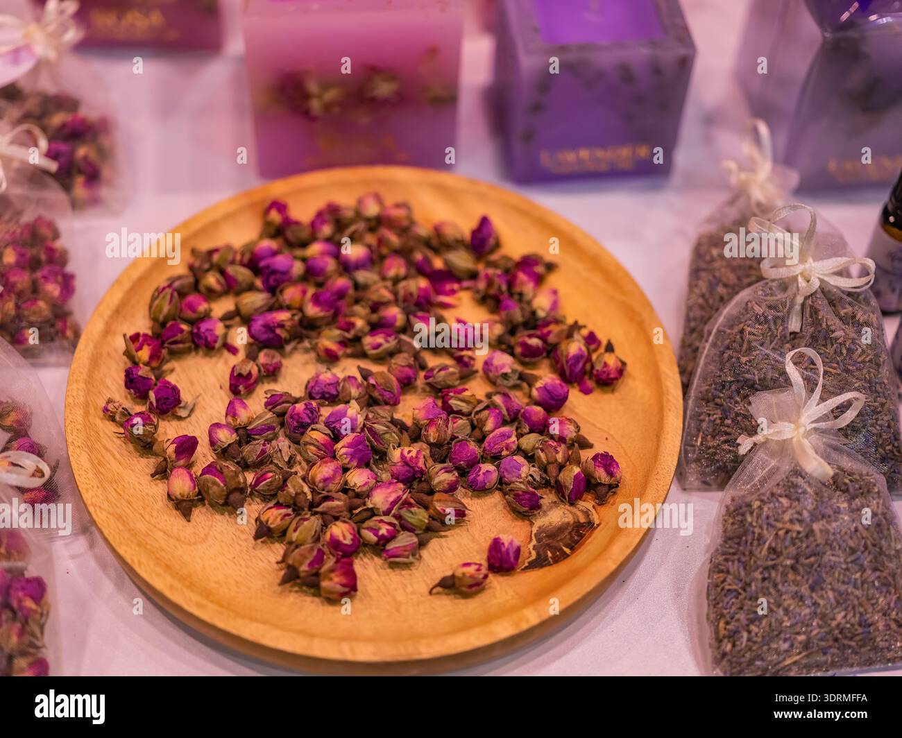 Boutons de rose séchés sur une assiette en bois Banque D'Images
