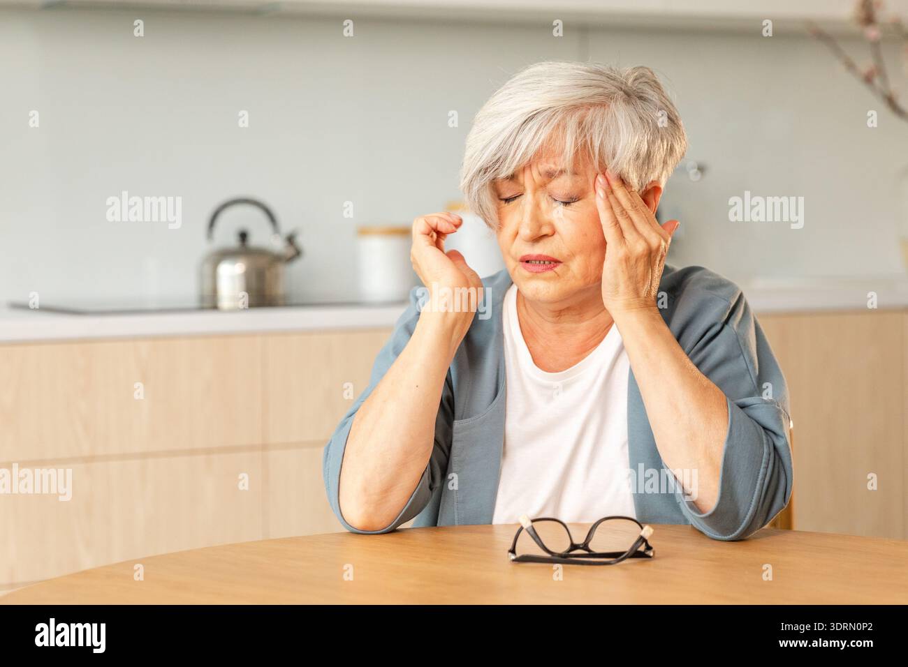 Mal de tête douleur, malheureuse femme âgée d'âge moyen souffrant de maux de tête malade frottant les tempes à la maison. Vieux grand-mot senior mature Banque D'Images