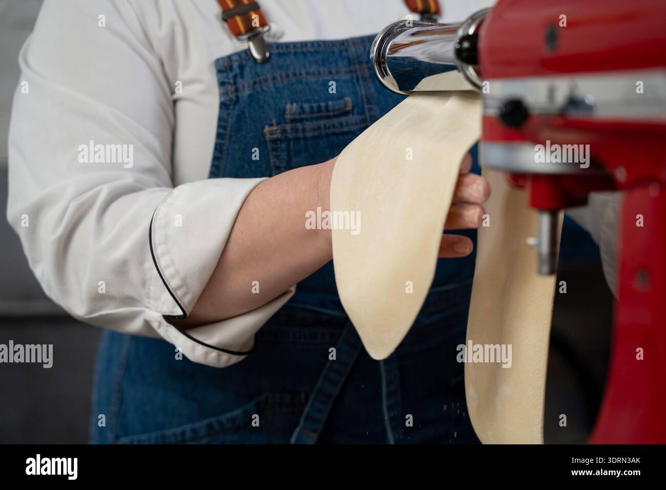 Gros plan du chef utilisant la machine à pâtes dans la cuisine. Banque D'Images