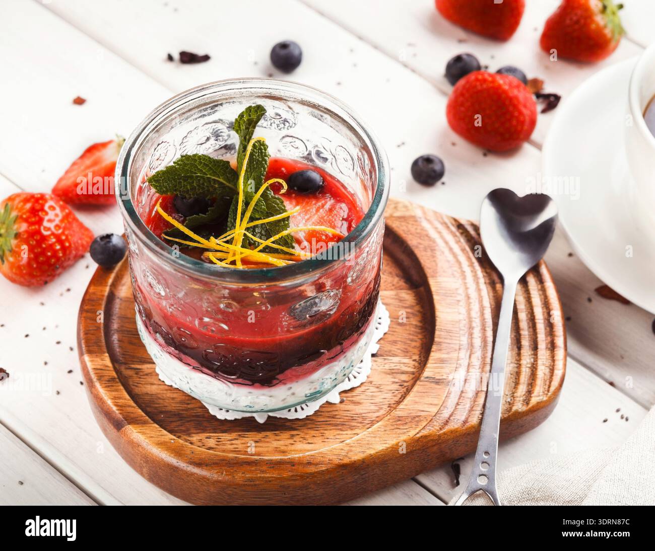 Collection de pots à dessert avec des fruits frais et de la crème sur un plateau en bois Banque D'Images