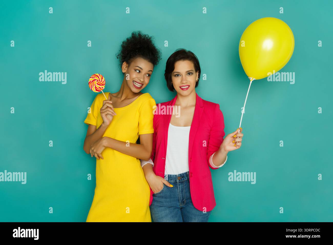Amis appréciant des couleurs vives avec des bonbons et des ballons lors d'un événement amusant Banque D'Images