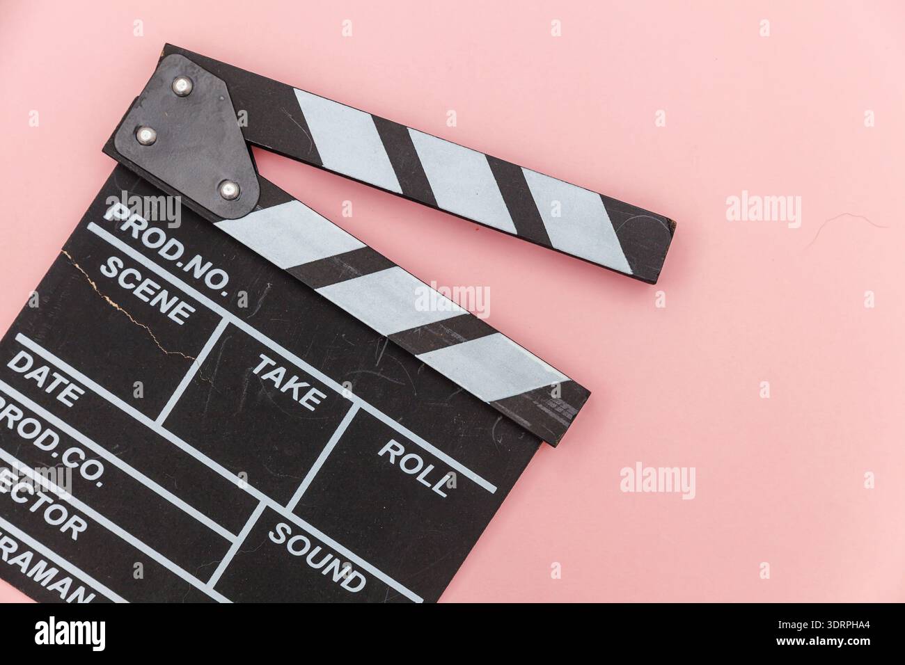 Profession de cinéaste. Réalisateur classique film vide faisant claquette ou ardoise de film isolé sur fond rose. Producti vidéo Banque D'Images