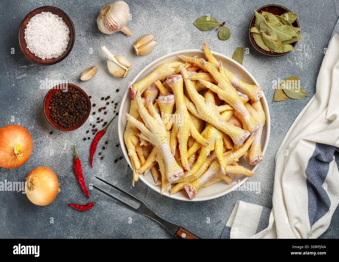 Pieds de poulet frais crus. Ingrédients pour cuisiner des plats indonésiens, thaïlandais, malaisiens et chinois - cuisses de poulet, grains de poivre, chi Banque D'Images