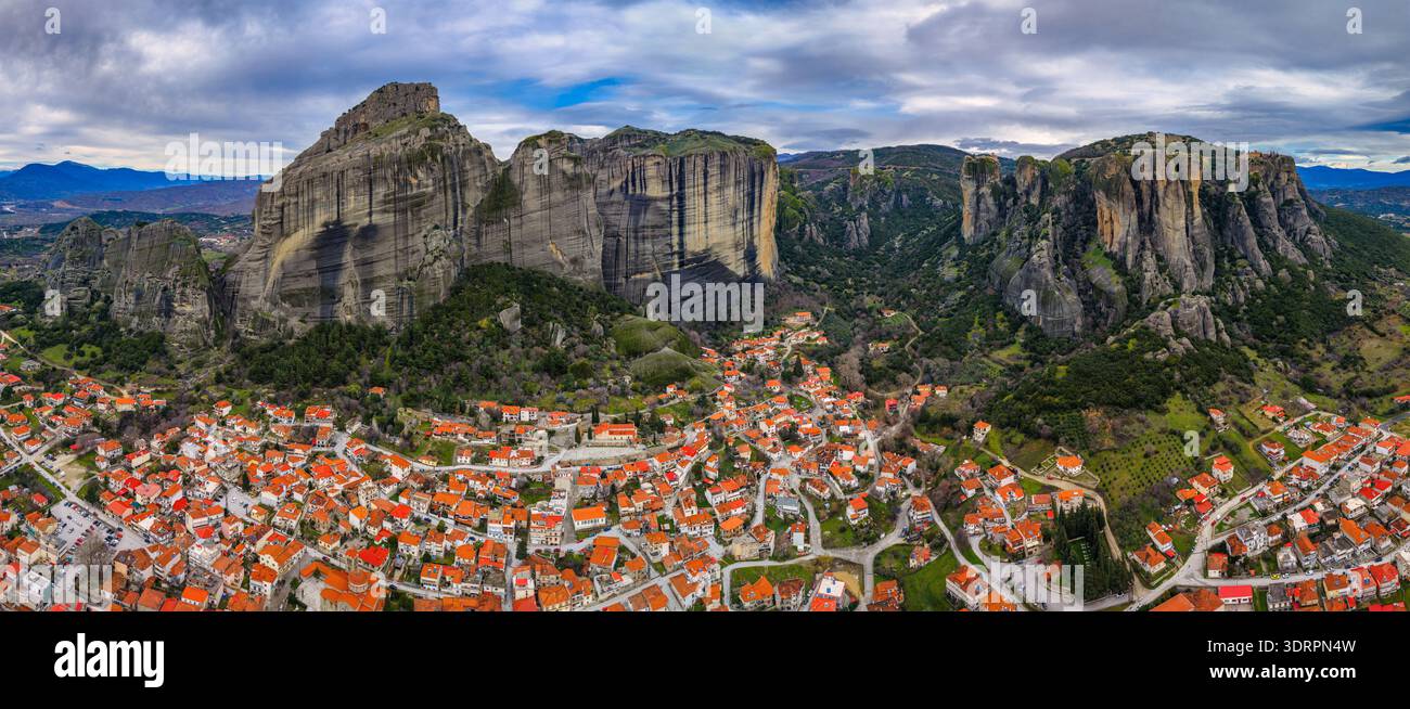 Kalambaka, Grèce. Photographie aérienne montrant les toits de tuiles rouges de la ville sous les imposants piliers rocheux des Météores, capturant le contraste entre u Banque D'Images