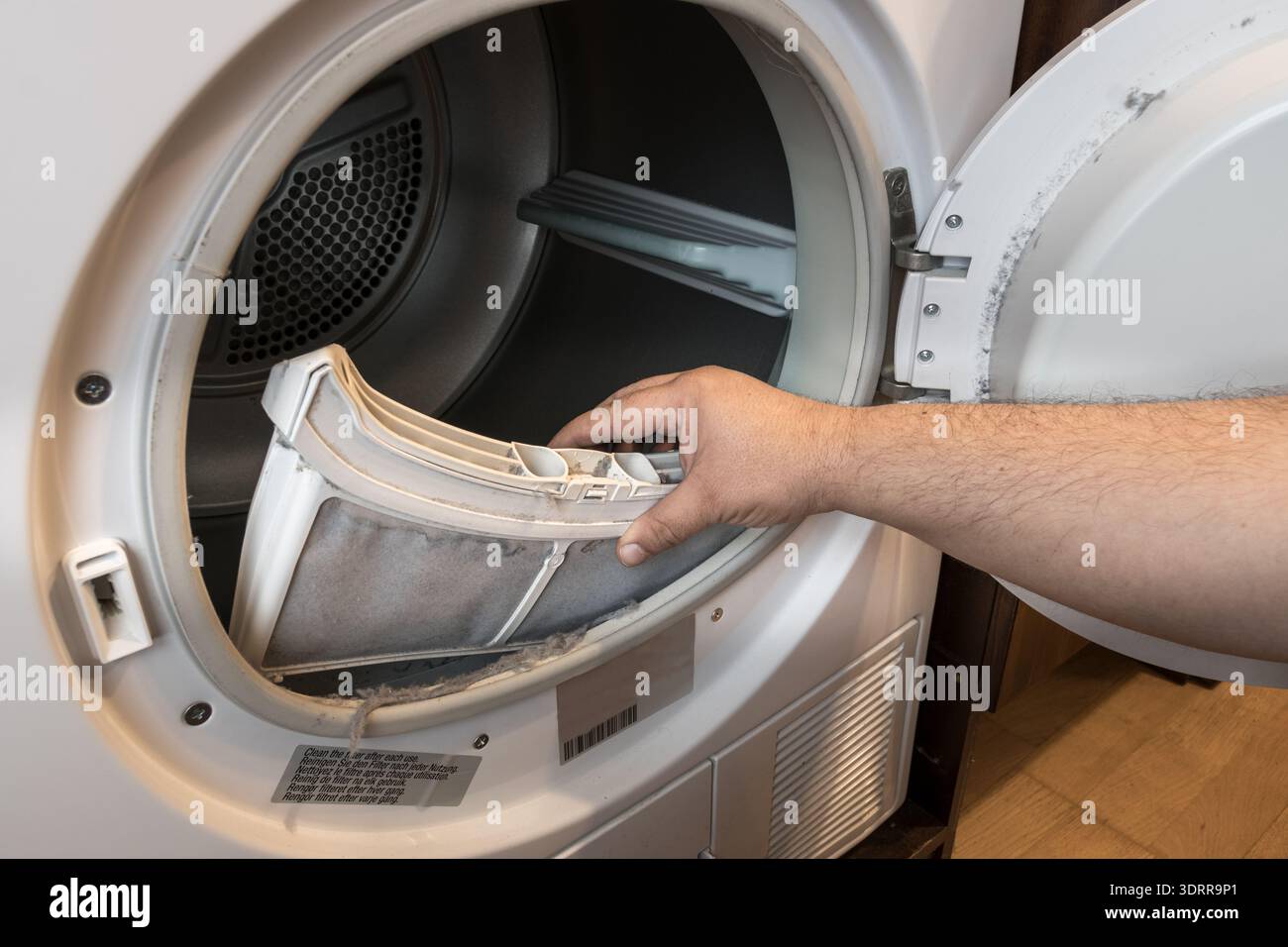 retrait manuel du filtre à peluches du sèche-linge Banque D'Images