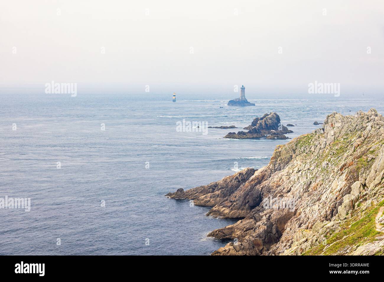Rochers au bord de la mer avec un phare Banque D'Images