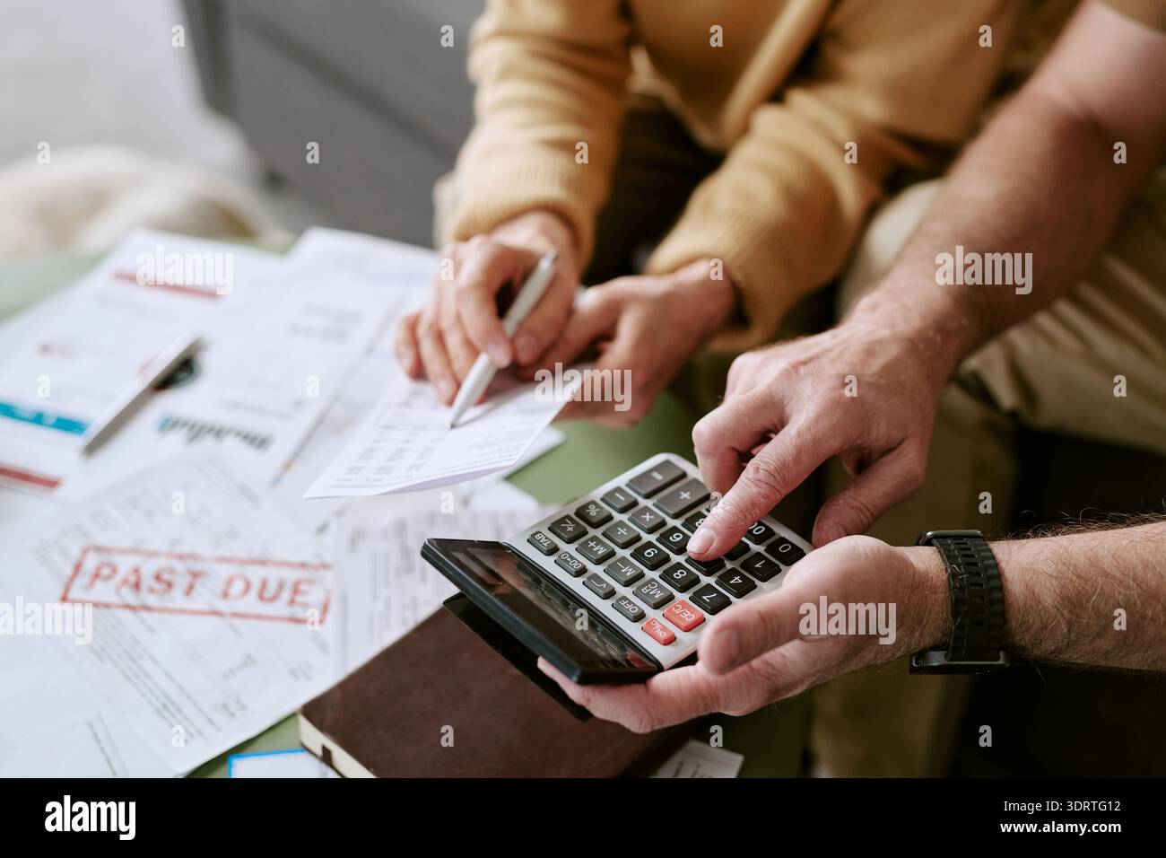 Homme et femme caucasiens supérieurs calculant des factures avec préavis en retard Banque D'Images