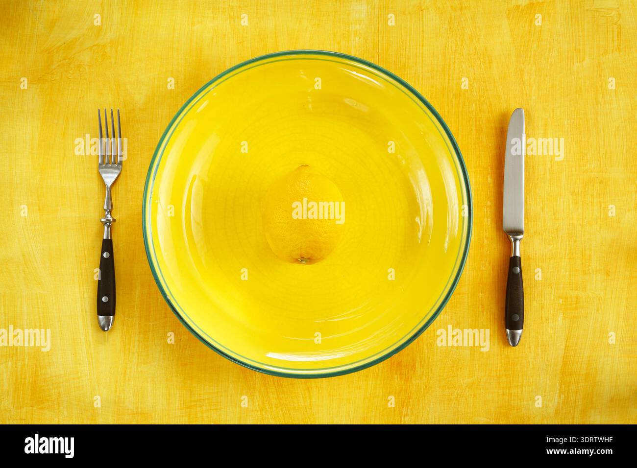 Régime et concept de réduction de poids, assiette avec couverts et un seul citron Banque D'Images