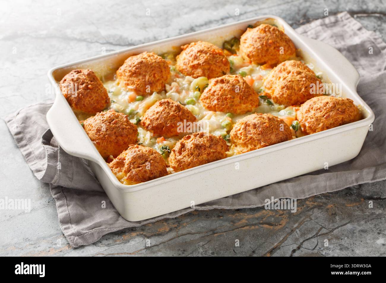 Casserole de poulet et biscuits faite avec du poulet râpé tendre, sauce crémeuse, et garnie de biscuits moelleux gros plan sur le plat de cuisson sur la table Banque D'Images