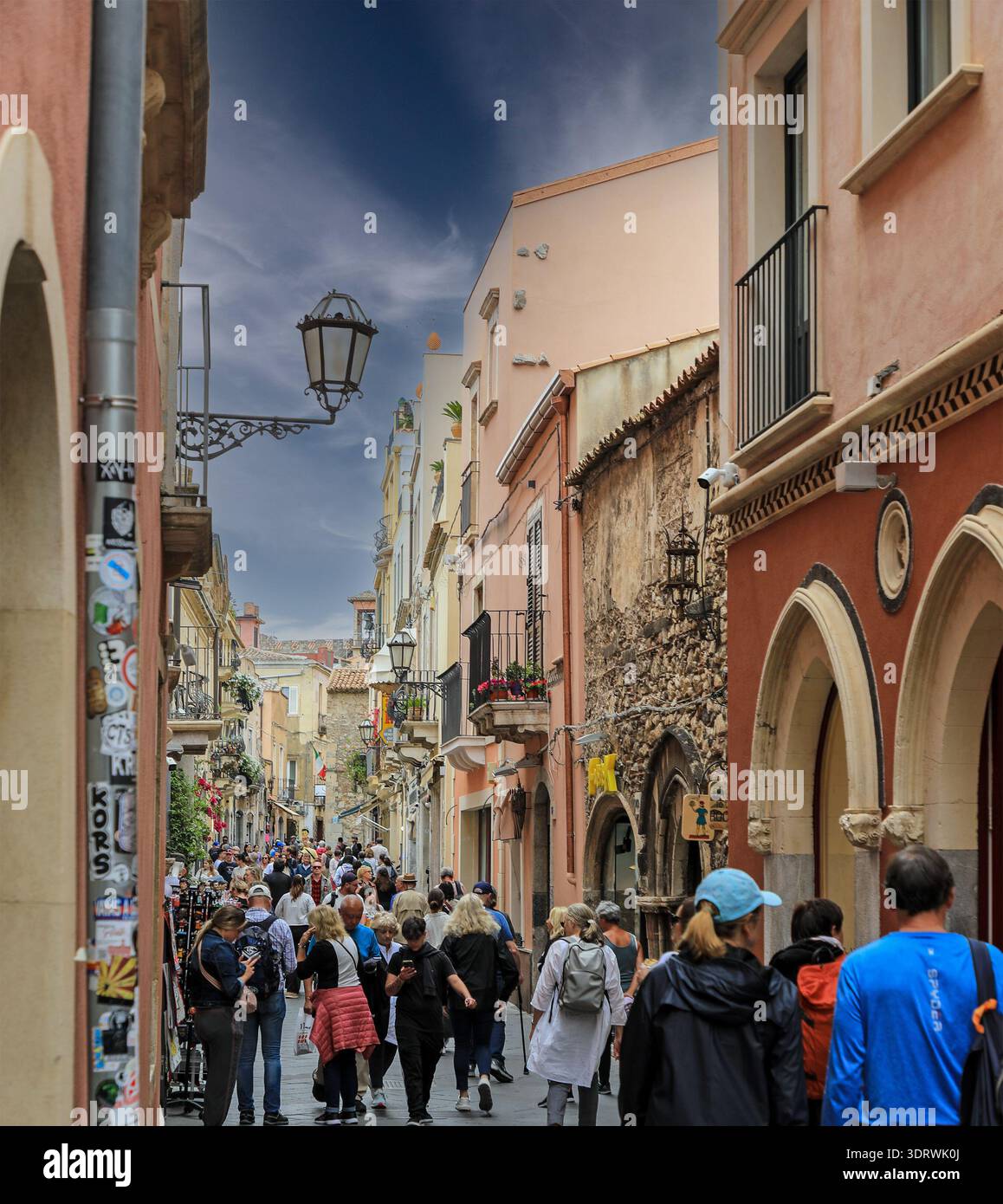 Une rue, Corso Umberto, animée par les touristes sous la pluie et les nuages noirs dans le centre de Taormine, Sicile, Italie, Europe Banque D'Images