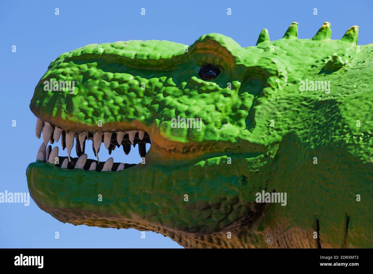 Gros plan d'une réplique semblable de taille réelle peinte en vert fluorescent d'un dinosaure Tyrannosaurus Rex éteint Banque D'Images