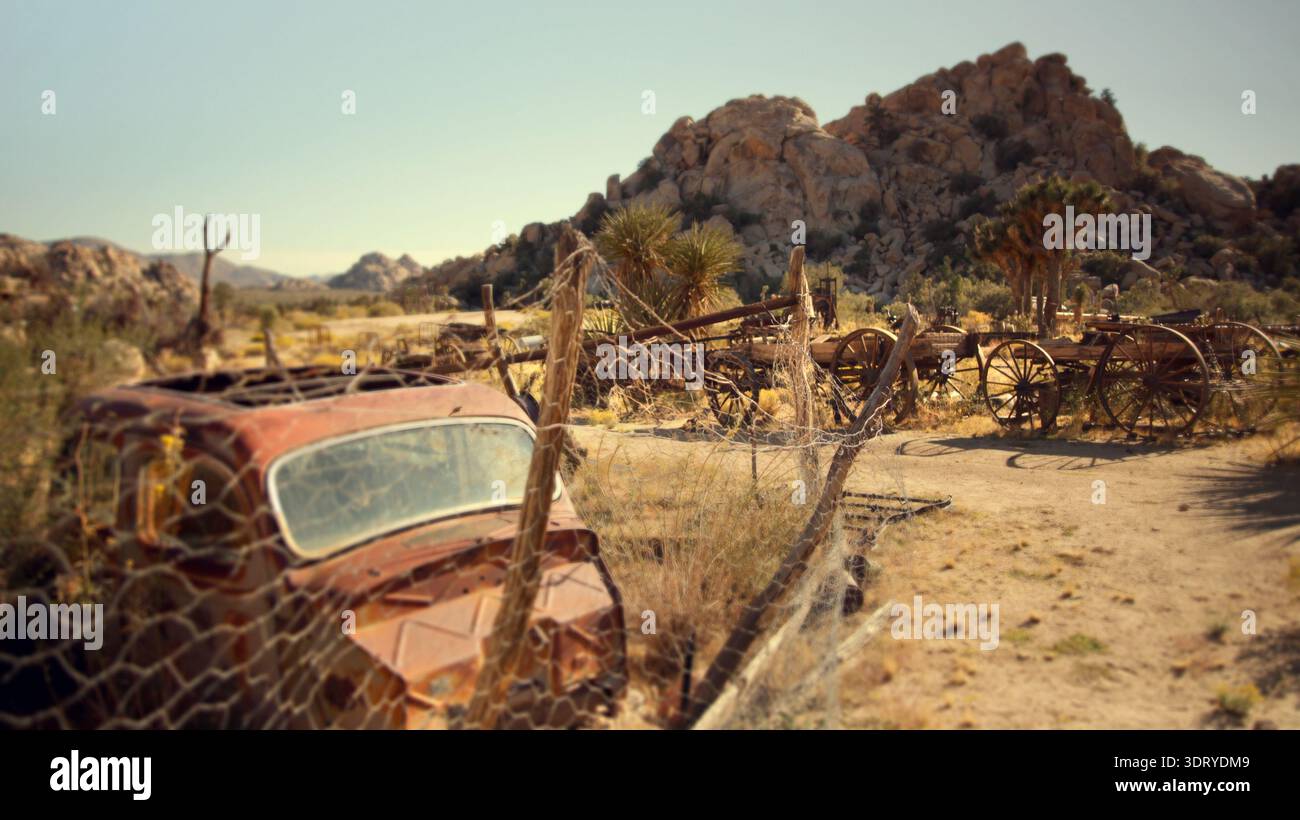 Une vieille carrosserie rouillée se trouve derrière une clôture en fil de fer au Keys Ranch historique dans le parc national de Joshua Tree, en Californie, en été. Banque D'Images