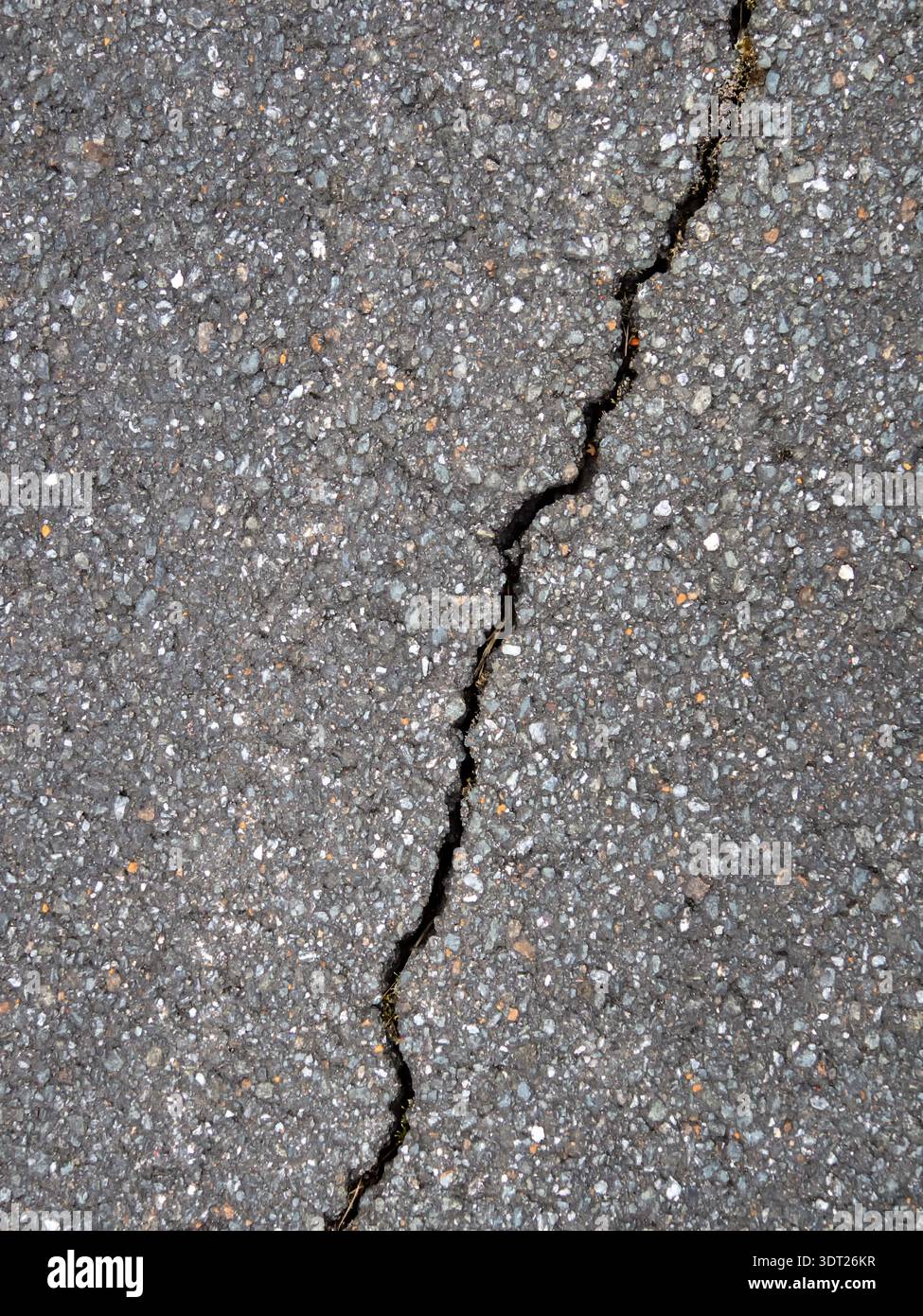 Gros plan d'une fissure diagonale dans l'asphalte noir Banque D'Images