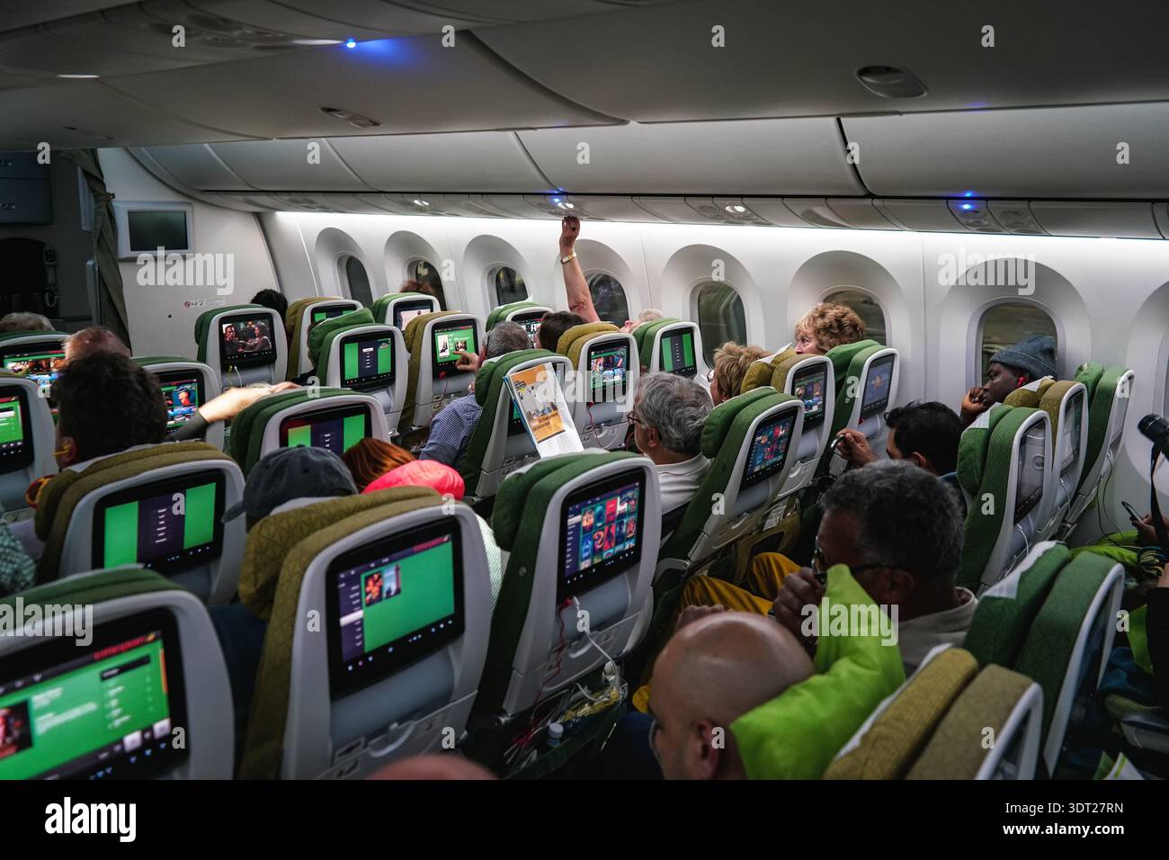 Schwechat, Autriche - 22 avril 2019 : passagers assis à leur place dans un avion commercial peu de temps avant le départ, regardant des films, verrouillage au-dessus de la tête Banque D'Images