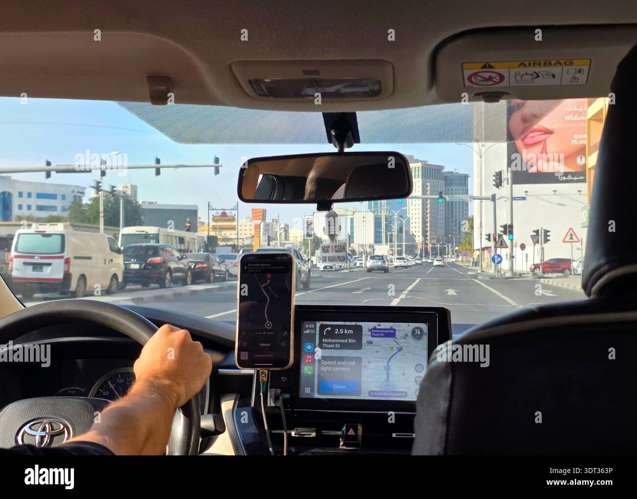 Doha, Qatar - Uber Driver navigant dans la ville. Point de vue d'un passager assis sur le siège arrière d'un véhicule covoituré. Un conducteur masculin tient la direction Banque D'Images