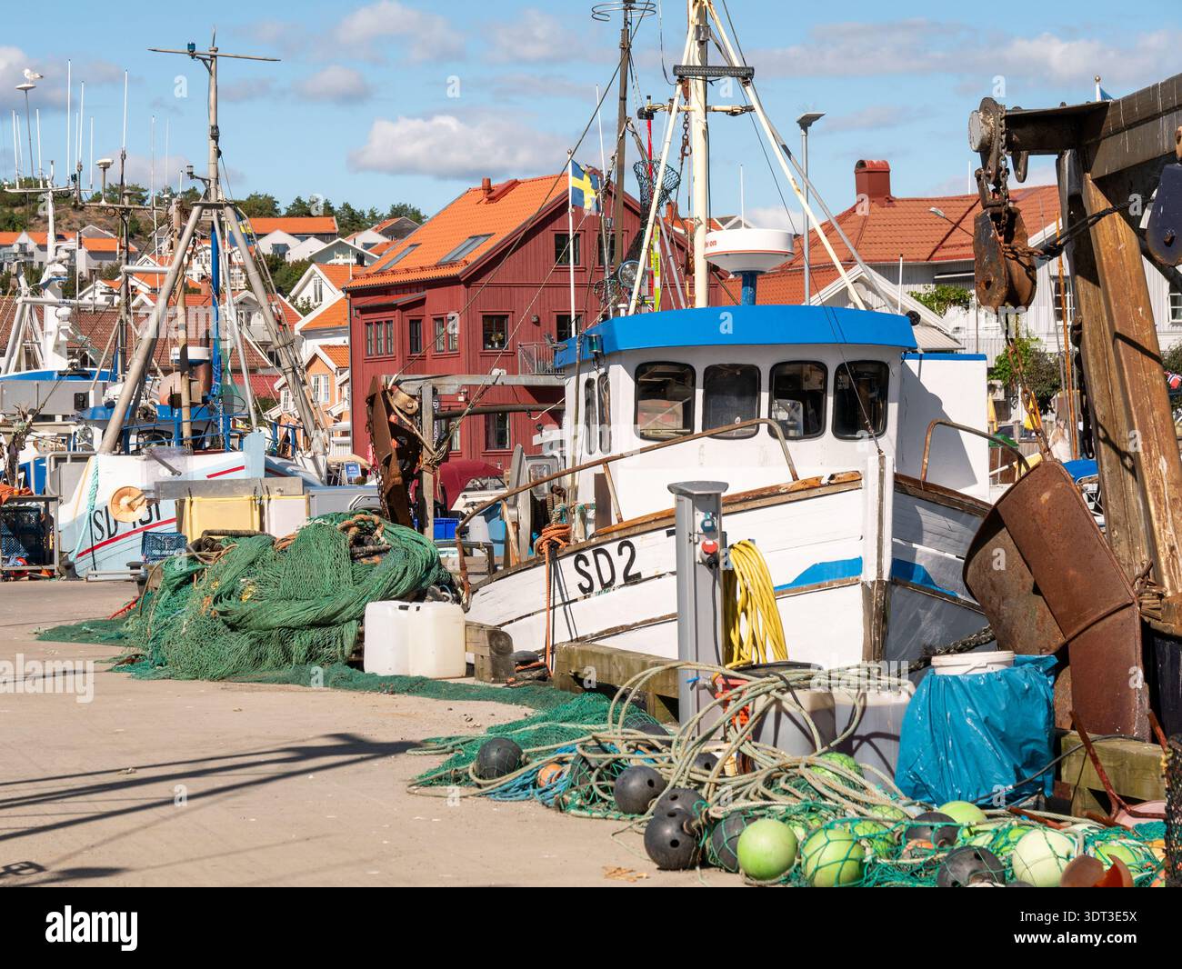 Chalutier de pêche amarré avec des filets et des engins le long du quai dans le port de Grebbestad, Bohuslän, côte ouest de la Suède Banque D'Images